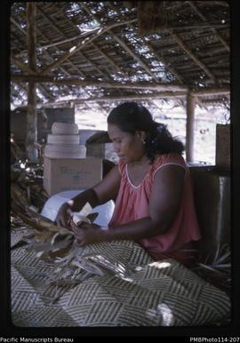 'Tebitera's wife making a palm frond mat, Wagina Island'