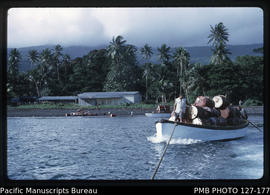'Whaleboat being towed from Somosomo beach with a load of empty oil drums, Fiji'