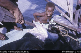 Malapu” fish [and child], Nifiloli village, Reef Islands