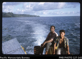 'Engine driver and crew member of punt as punt moves between different beaches, Fiji'