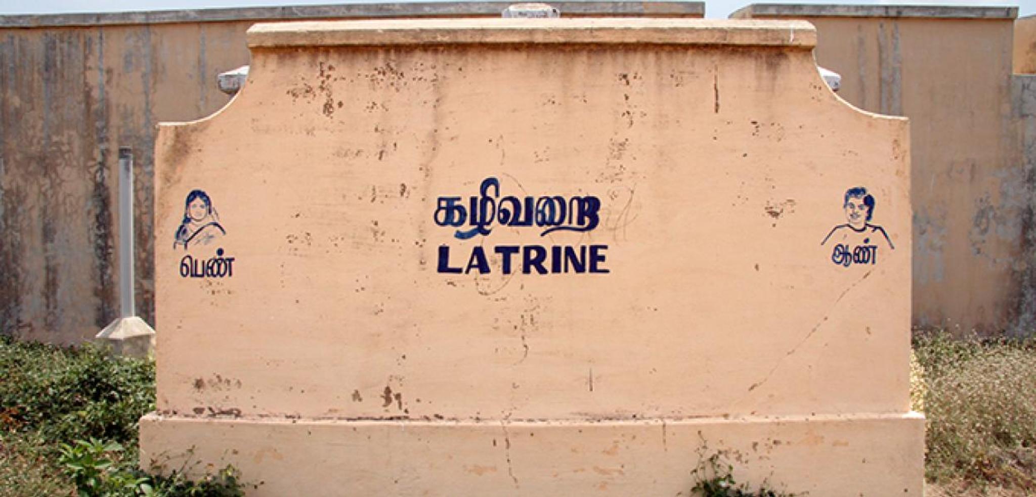 Outside wall of a concrete toilet building with Latrine written on the side