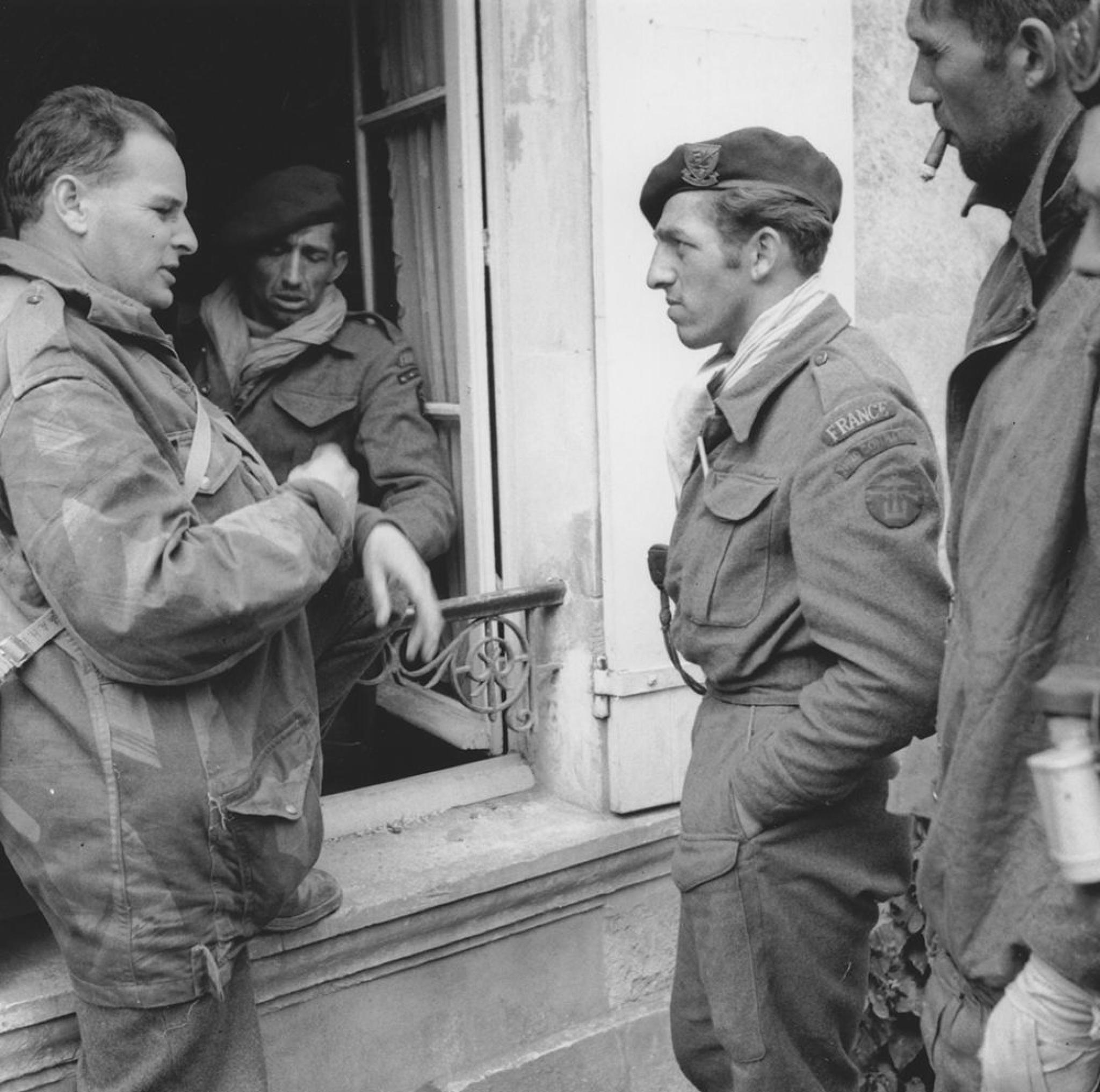 Image: Australian war correspondent Chester Wilmot talking to some French commandos of 10 (Inter-Allied) Commando in in Amfreville, Normandy, on 9 June 1944.