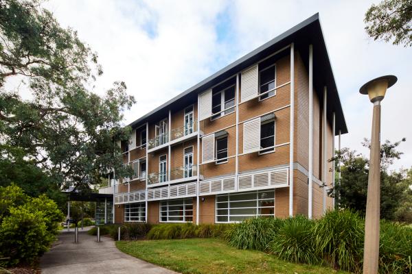 RegNet Building exterior - 3 floor building with white shutters surrounded by a path, trees and grass