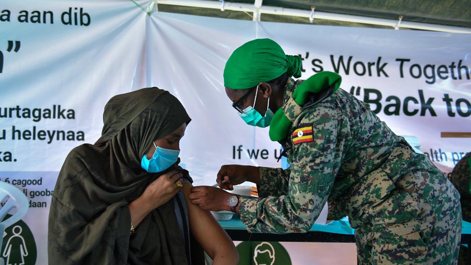 Image of Somalian woman shopkeeper getting Covid-19 vaccination by AMISOM Public Information at https://flic.kr/p/2mk63ji (CC0 1.0)