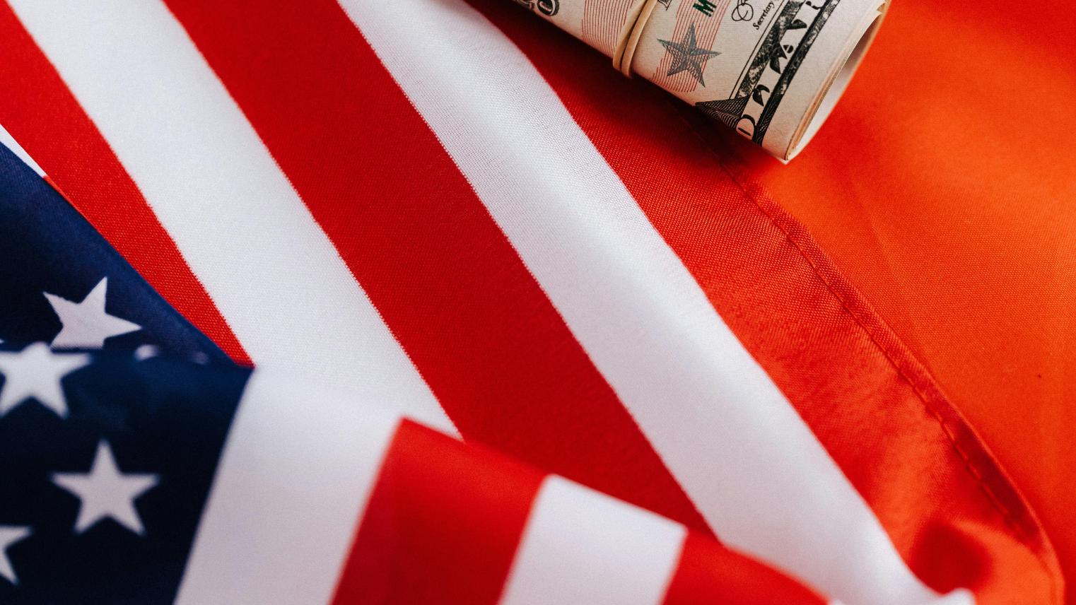 Image: Kaboompics.com from Pexels: https://www.pexels.com/photo/bright-american-flag-with-roll-of-greenbacks-4386344/