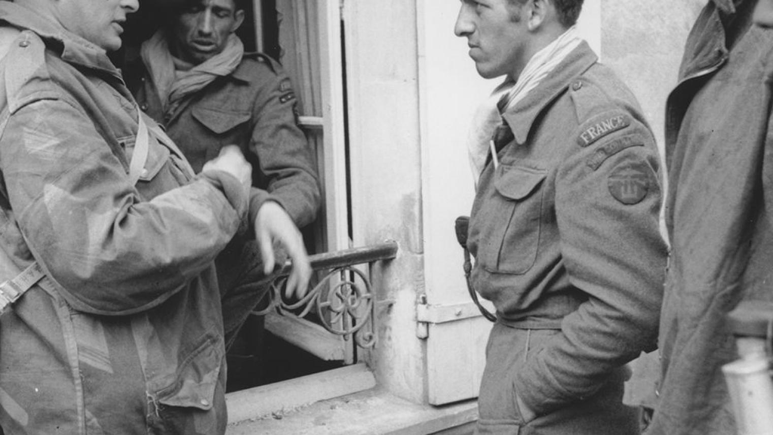 Image: Australian war correspondent Chester Wilmot talking to some French commandos of 10 (Inter-Allied) Commando in in Amfreville, Normandy, on 9 June 1944.