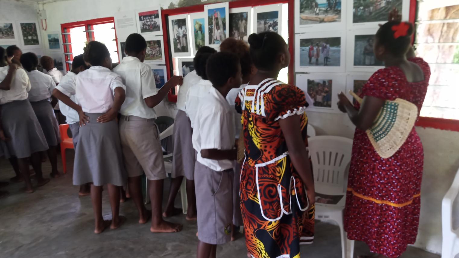 Teachers and secondary students at Wintua inspect the historic photographs. Photographer, Paul Mitchell